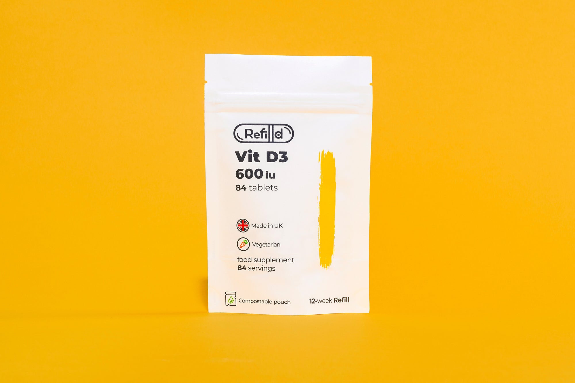 Refilld Vit D3 compostable pouch for a 12-week supply, displayed on a yellow background. compostable pouch, 12-week supply, yellow background