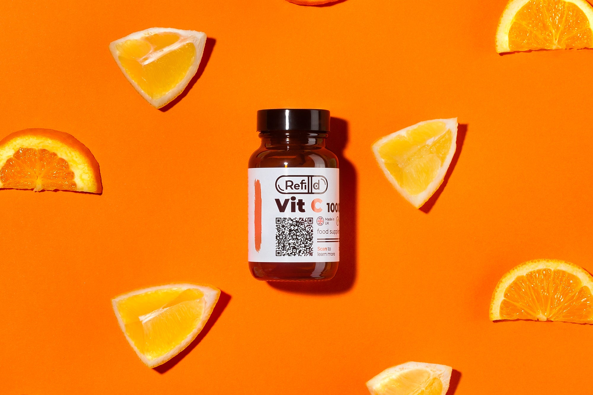 Refilld Vit C 1000 mg bottle surrounded by orange slices and lemon wedges on an orange background.
Refilld Vit C 1000 mg, food supplement, vitamin C, orange slices, orange background, immunity support, natural sources